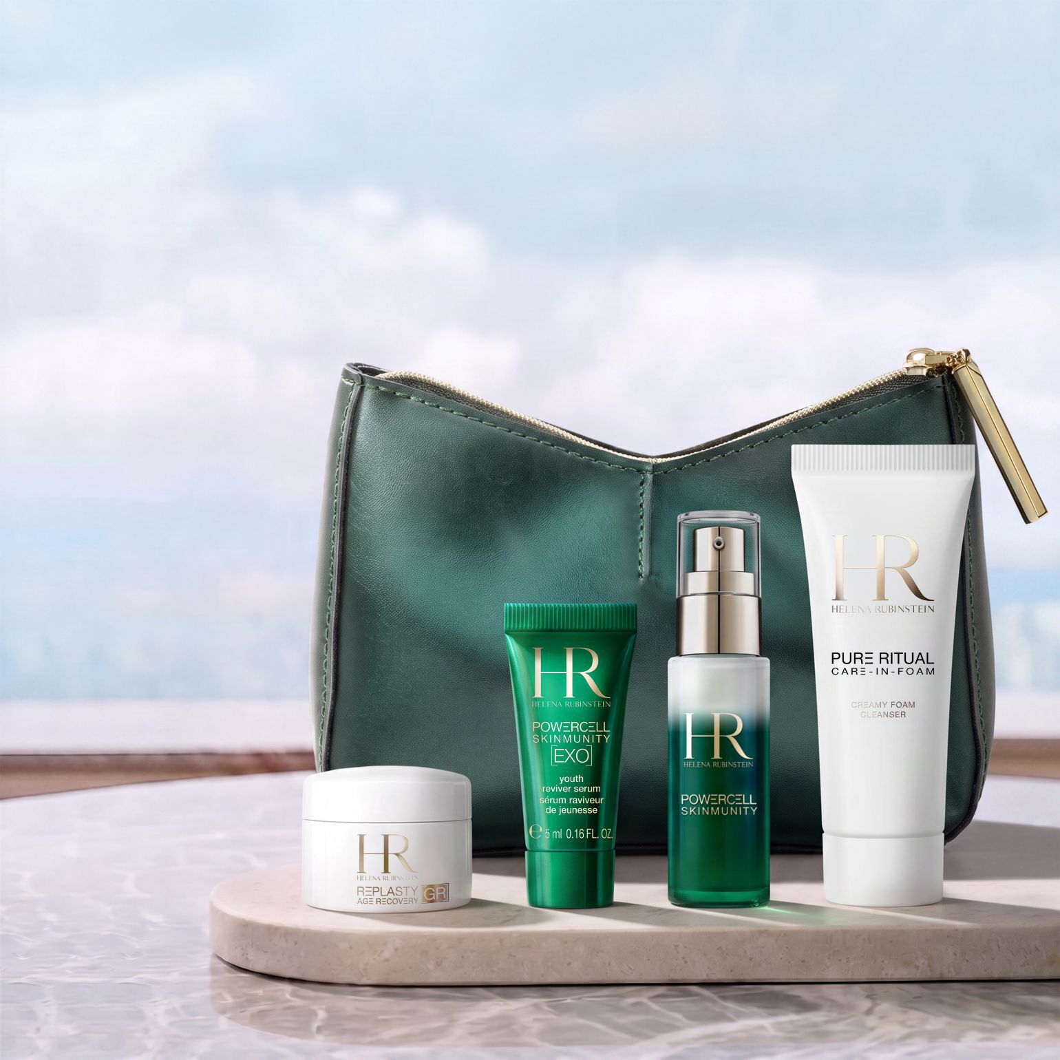 Une trousse de toilette verte Helena Rubinstein posee devant un paysage lumineux, entouree de quatre produits miniatures : une creme Re-Plasty, un mini serum Powercell [EXO], un serum Powercell Skinmunity et un nettoyant Pure Ritual.​
