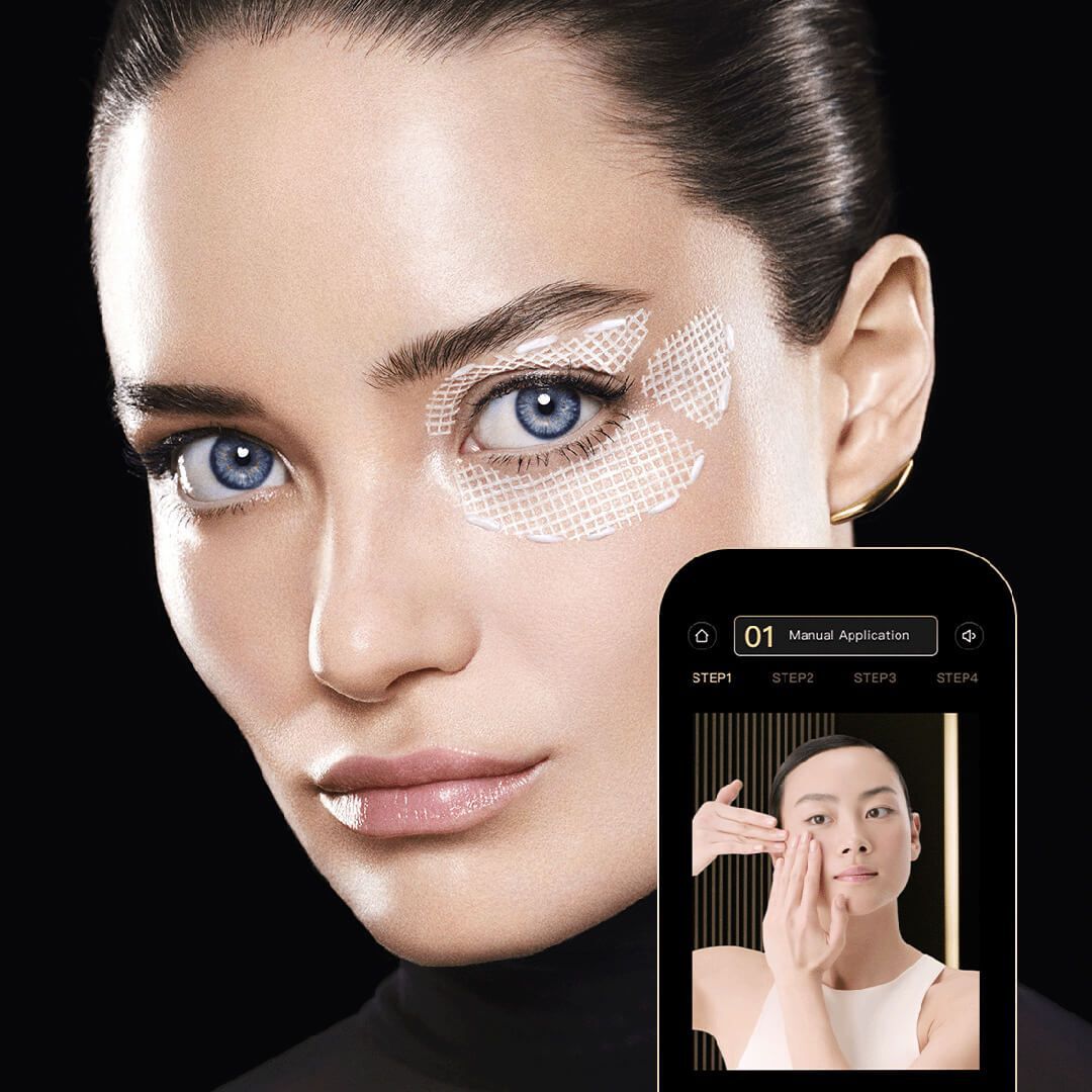 Gros plan sur le visage d'une femme avec des patchs oculaires. Un telephone affiche un tutoriel.