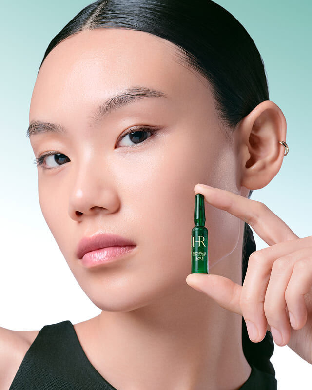 Mannequin tenant une ampoule Powercell Skinmunity EXO verte.