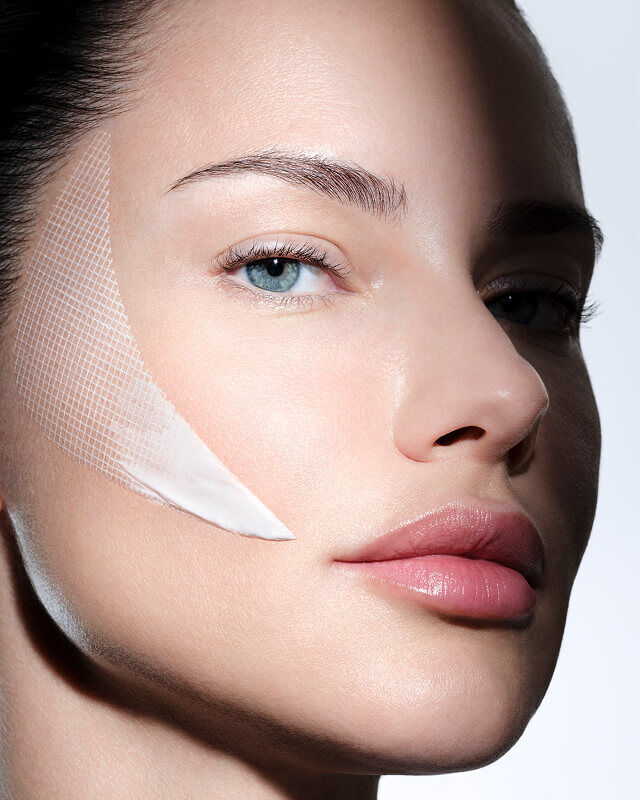 Visage de femme avec la creme Helena Rubinstein REPLASTY et sa texture pansement innovante sur la joue.
