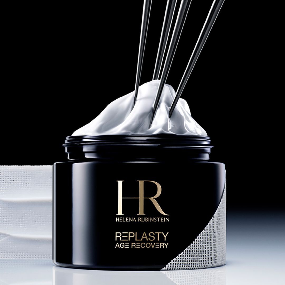 Banniere Helena Rubinstein Re-Plasty Age Recovery : pot de creme noir elegant, au centre, avec des reflets dores et des elements liquides ambres en arriere-plan. Ambiance sombre et luxueuse.​