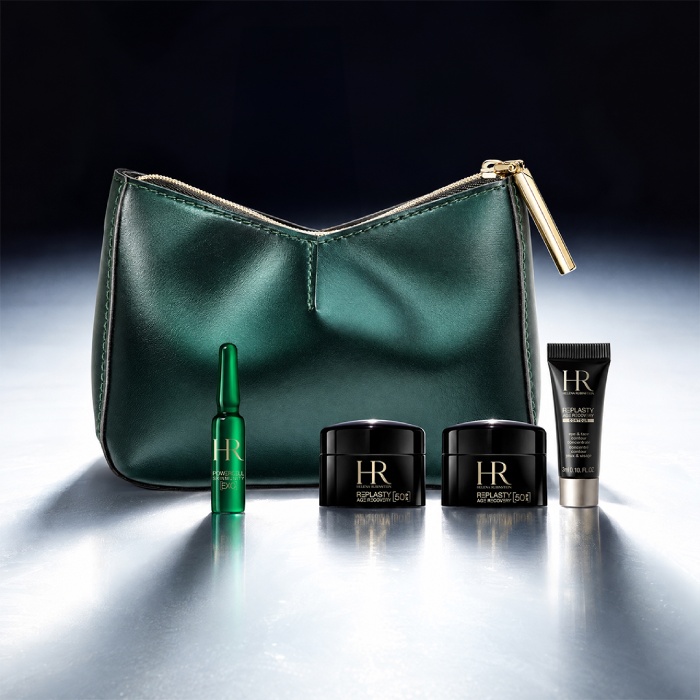 Une trousse de toilette verte Helena Rubinstein posée devant un paysage lumineux, entourée de quatre produits miniatures : une crème Re-Plasty, un mini sérum Powercell [EXO], un sérum Powercell Skinmunity et un nettoyant Pure Ritual.​